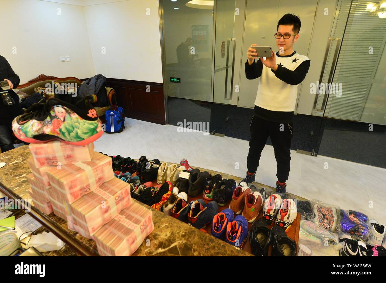 30-año-viejo hombre chino Mick, izquierda, el propietario de 283 pares de  zapatillas de deporte Nike Jordan, toma fotos de ladrillos de 100 yuan  renminbi (RMB) billetes después Fotografía de stock - Alamy