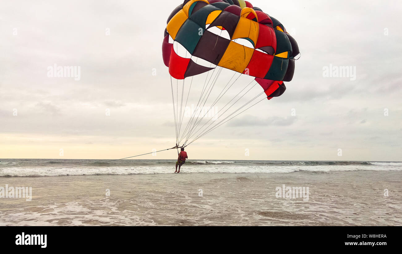Parapente deportes extremos en la playa en el atardecer. Foto de stock