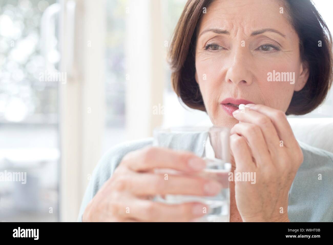 Mujer madura tomando tabletas. Foto de stock