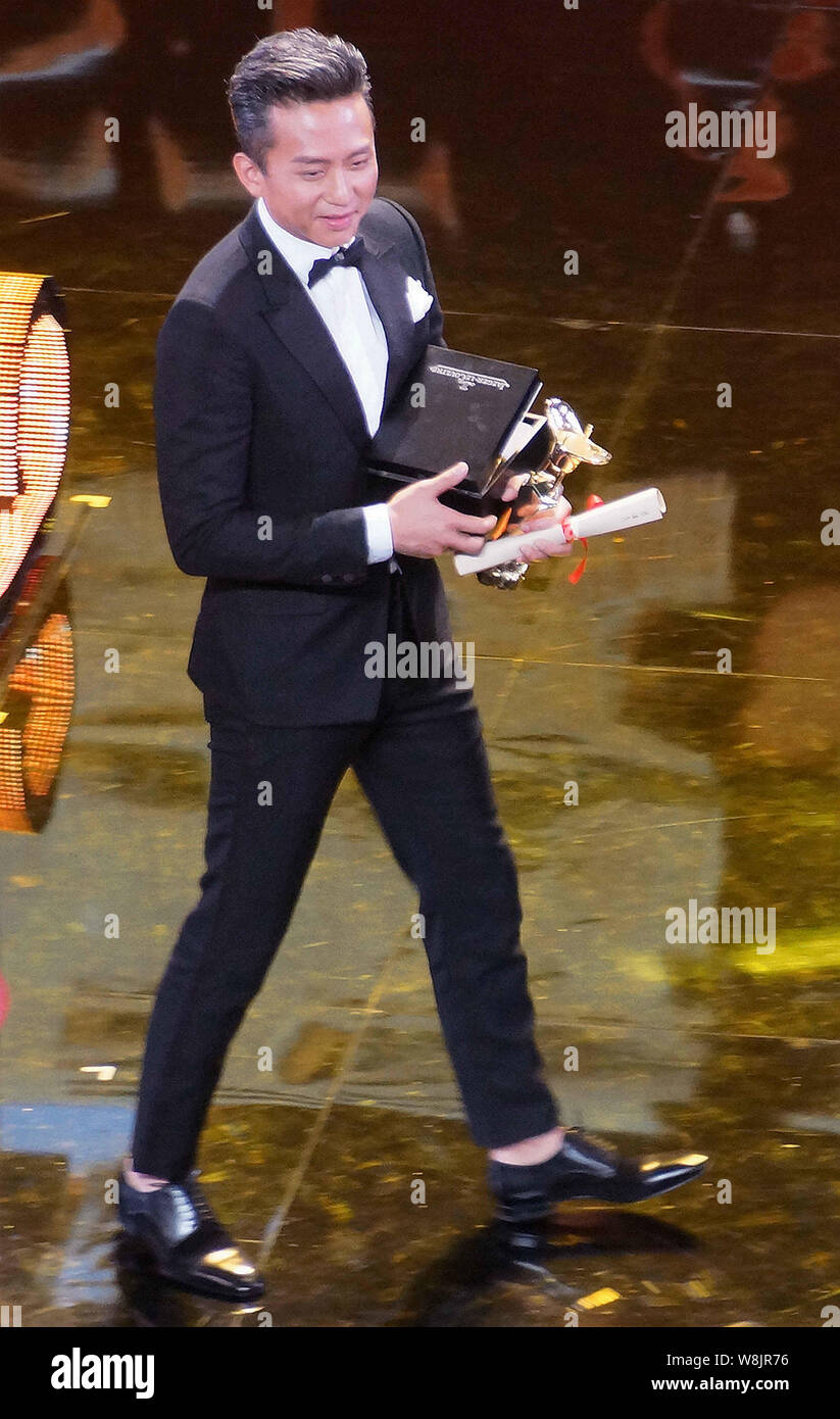 Actor chino Deng Chao celebra su trofeo después de ganar el premio al mejor actor en la ceremonia de clausura de la 18ª edición del Festival Internacional de Cine de Shanghai Foto de stock
