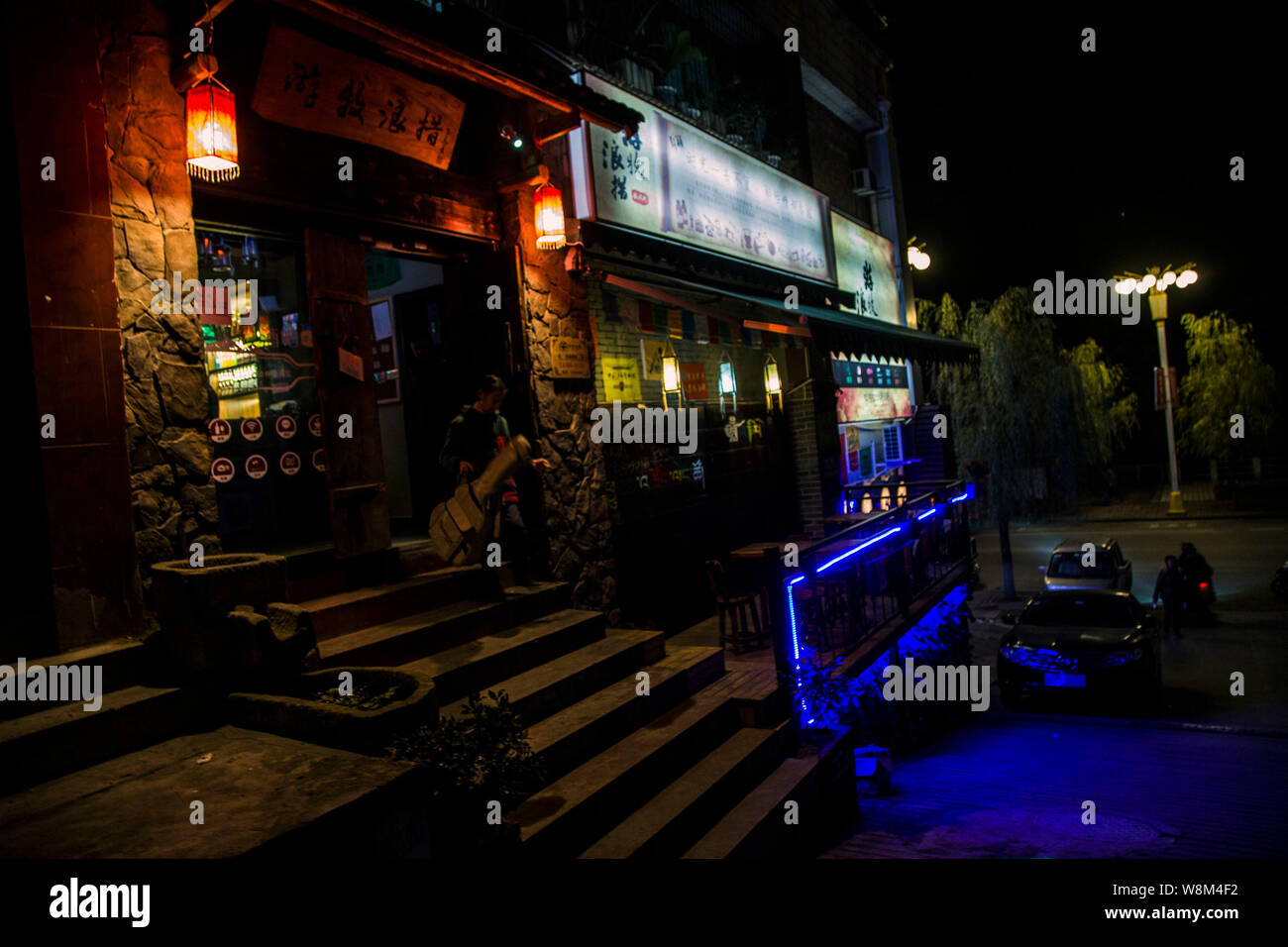 Ancianos mujer chino Cai Yuanxiu llevando su guitarra deja un pub en Yunyang County, Chongqing, China, el 11 de enero de 2016. Mujer chino Cai Yuanxiu i Foto de stock