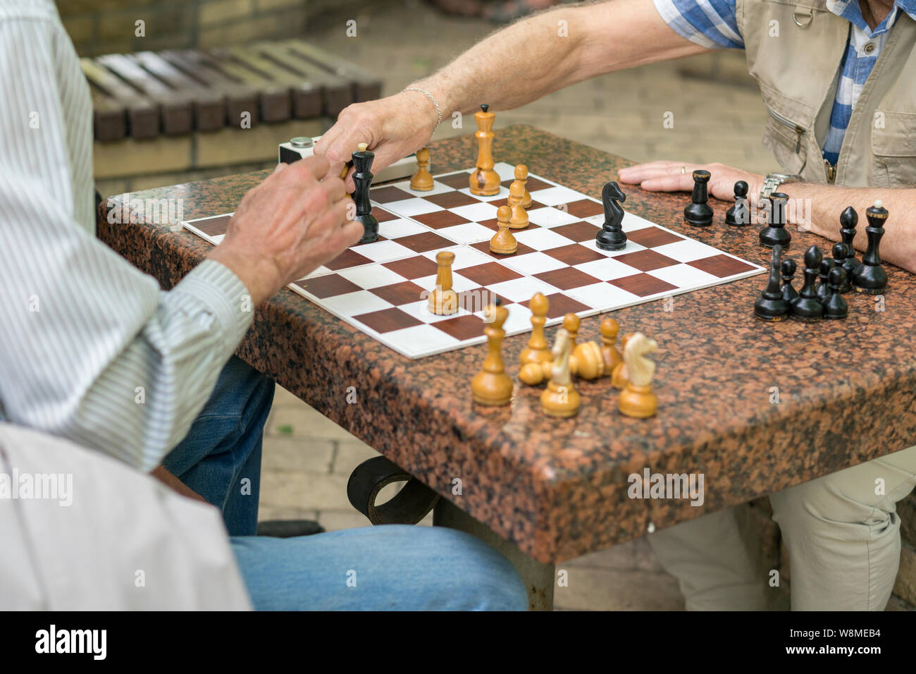 Active los jubilados, viejos amigos y el tiempo libre, los ancianos a  divertirse y jugar un juego de ajedrez en el parque. Cintura para arriba.  Viejos jugando al ajedrez en el parque