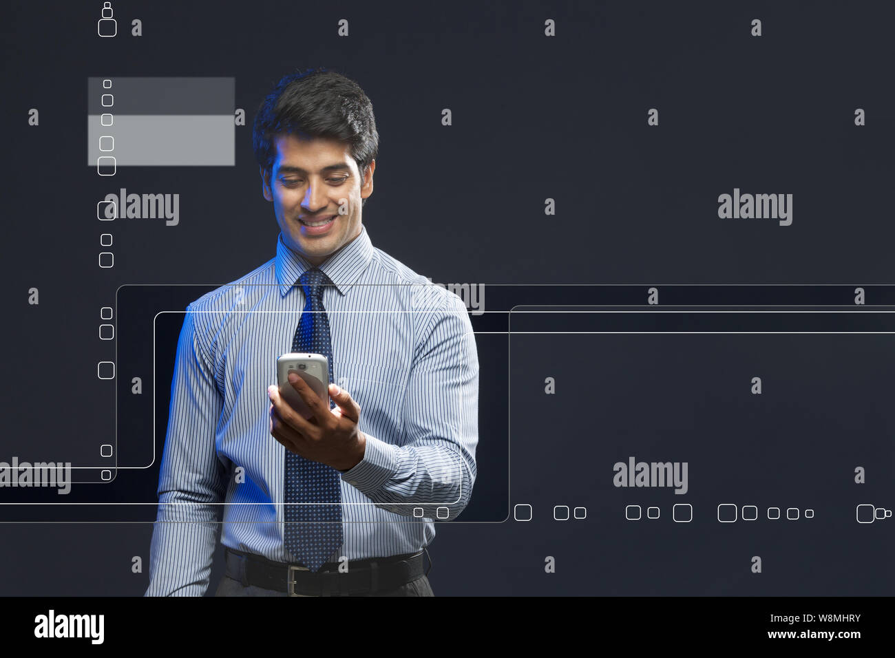 Hombre de negocios que utiliza un smartphone cerca de una pantalla táctil Foto de stock