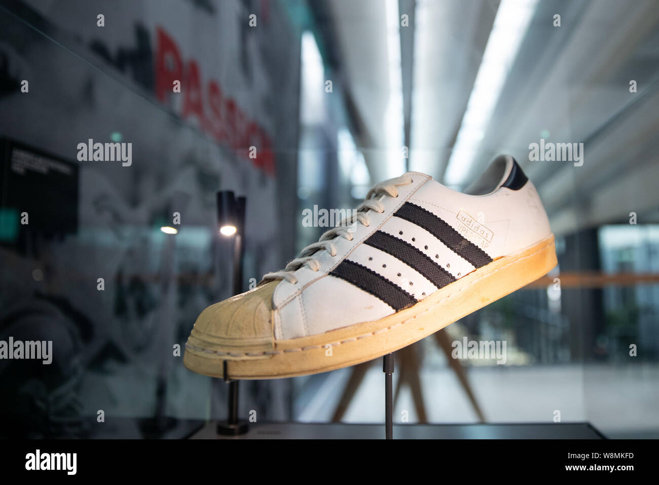 Herzogenaurach, Alemania. 09Aug, 2019. El modelo de zapato 'Superstar'  desde 1970 por el fabricante de artículos deportivos Adidas es en una  exposición sobre la historia de la marca detrás de un vidrio.