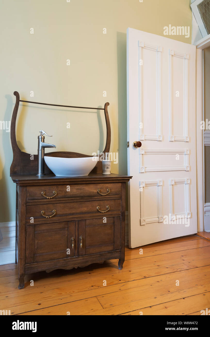 Madera de roble antiguo tocador con lavabo en tazón de agua blanca manchada  de vestidor con suelo de madera de pino de estilo victoriano de 1900 en una  antigua casa de estilo