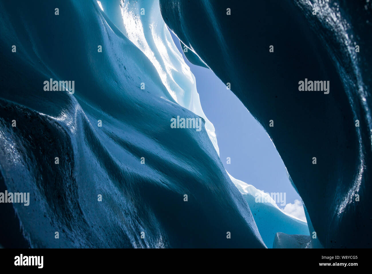 Hielo azul suave de un curvy crevasse amurallada en un glaciar alpino en Alaska. Foto de stock