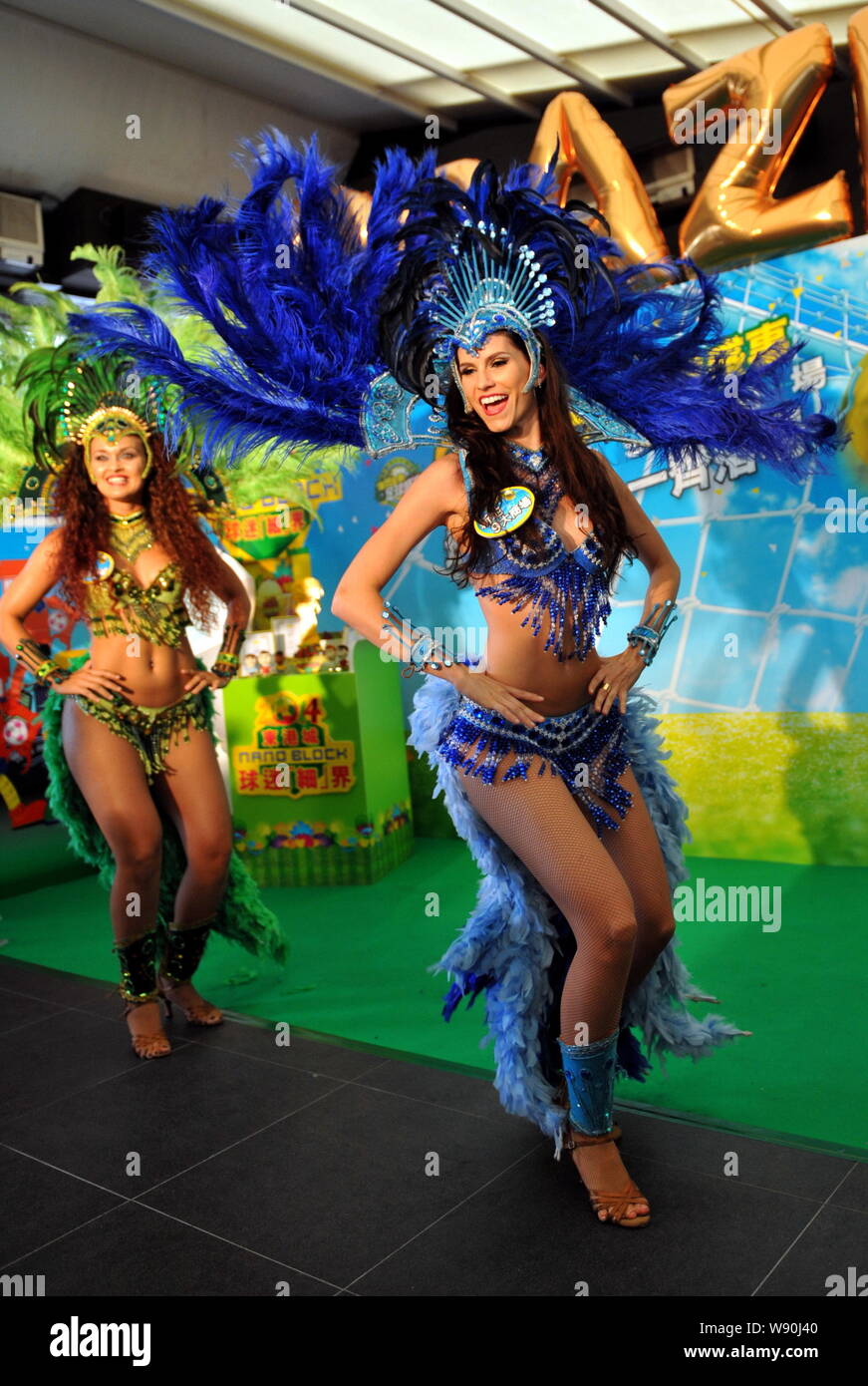 Las bailarinas vestidas con trajes de baile de samba samba durante un  evento para celebrar la próxima Copa del Mundo Brasil 2014 en un centro  comercial de Hong Kong, China Fotografía de
