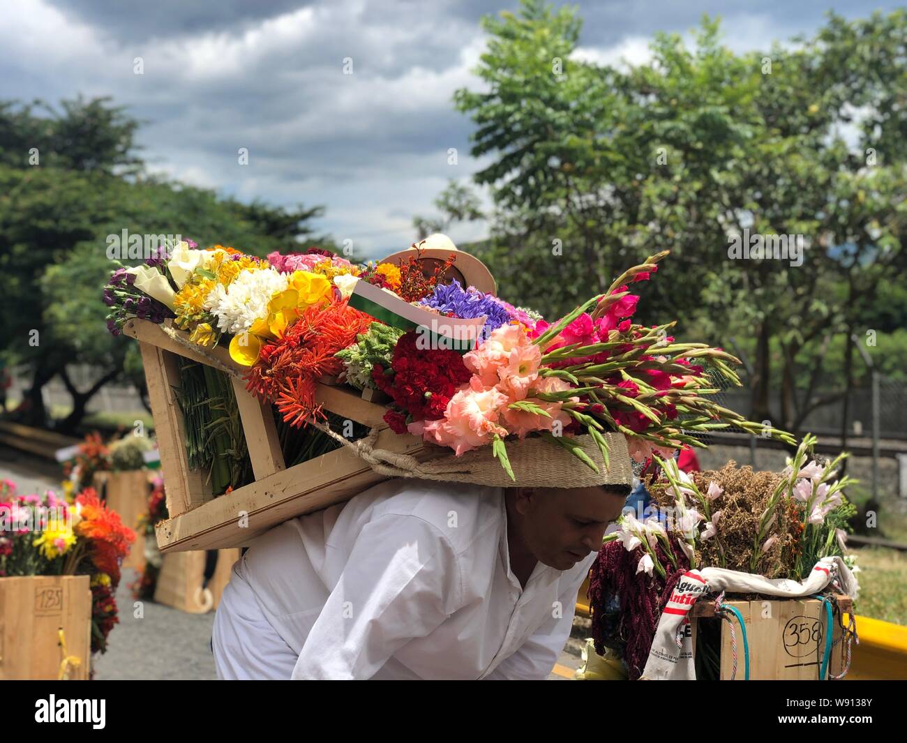 El departamento de Antioquia, Colombia. 11 Aug, 2019. Un hombre llevando  flores en la espalda es visto en un desfile durante el festival de las  flores en Medellin, Antioquia, Colombia, el 11