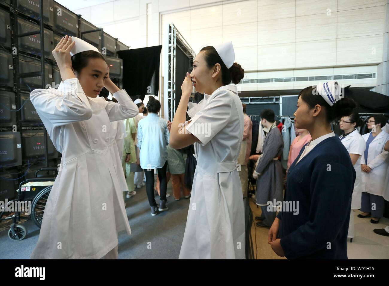 Enfermeras chinas se preparan para la presentación del nuevo hospital uniformes durante un desfile de moda en Beijing, China, 1 de abril de 2013. Un desfile de moda especial fue Foto de stock