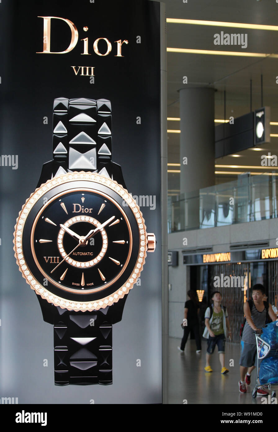 FILE chino pasajeros pasar un anuncio de Dior relojes en el