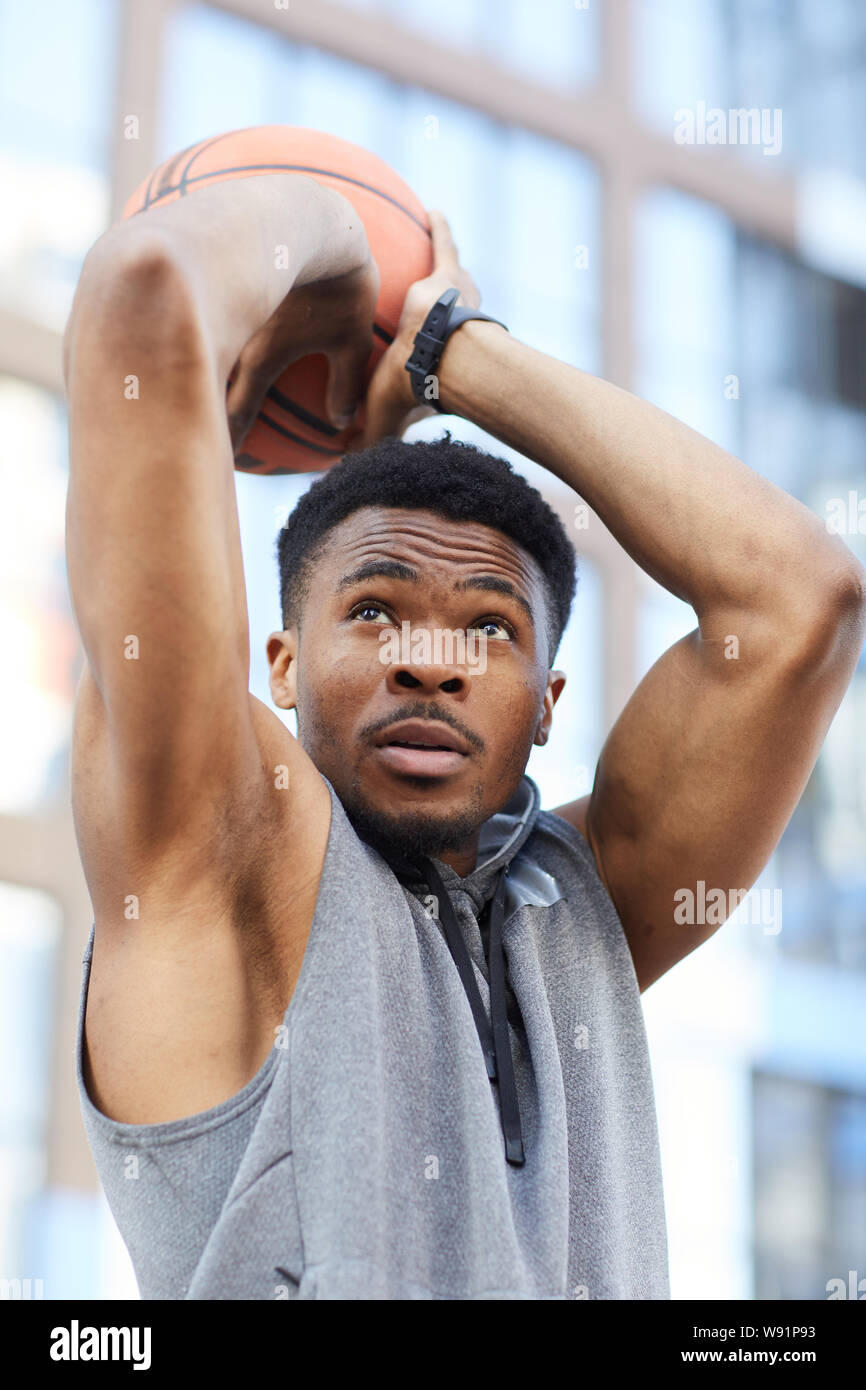 Retrato de acción africana de jugador de baloncesto disparar la bola mientras practica en corte exterior Foto de stock