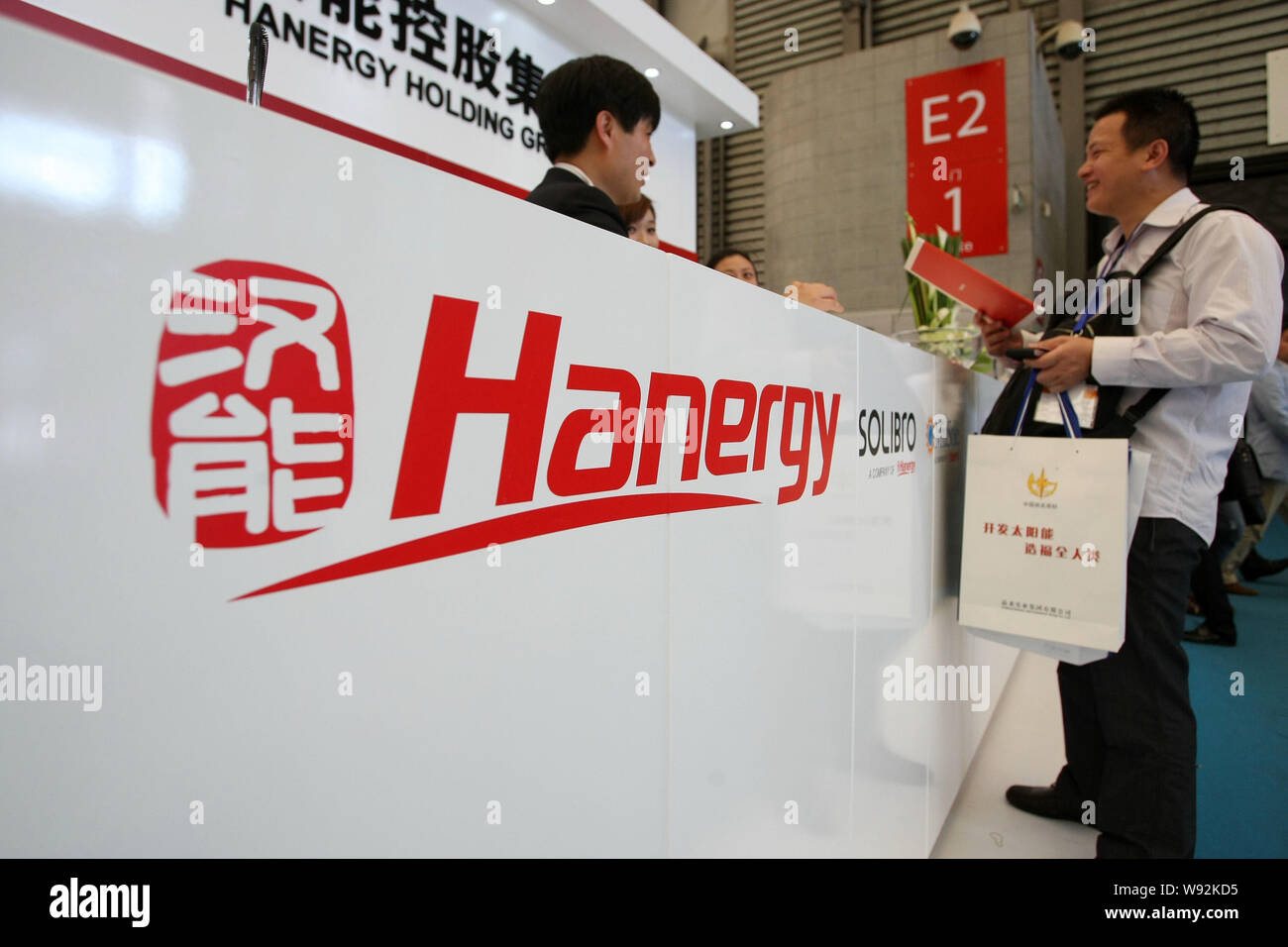 Un hombre chino visita el stand de Hanergy Holding Group durante la séptima (2013) la generación de energía fotovoltaica internacional Conference & Exhibition (SNE Foto de stock