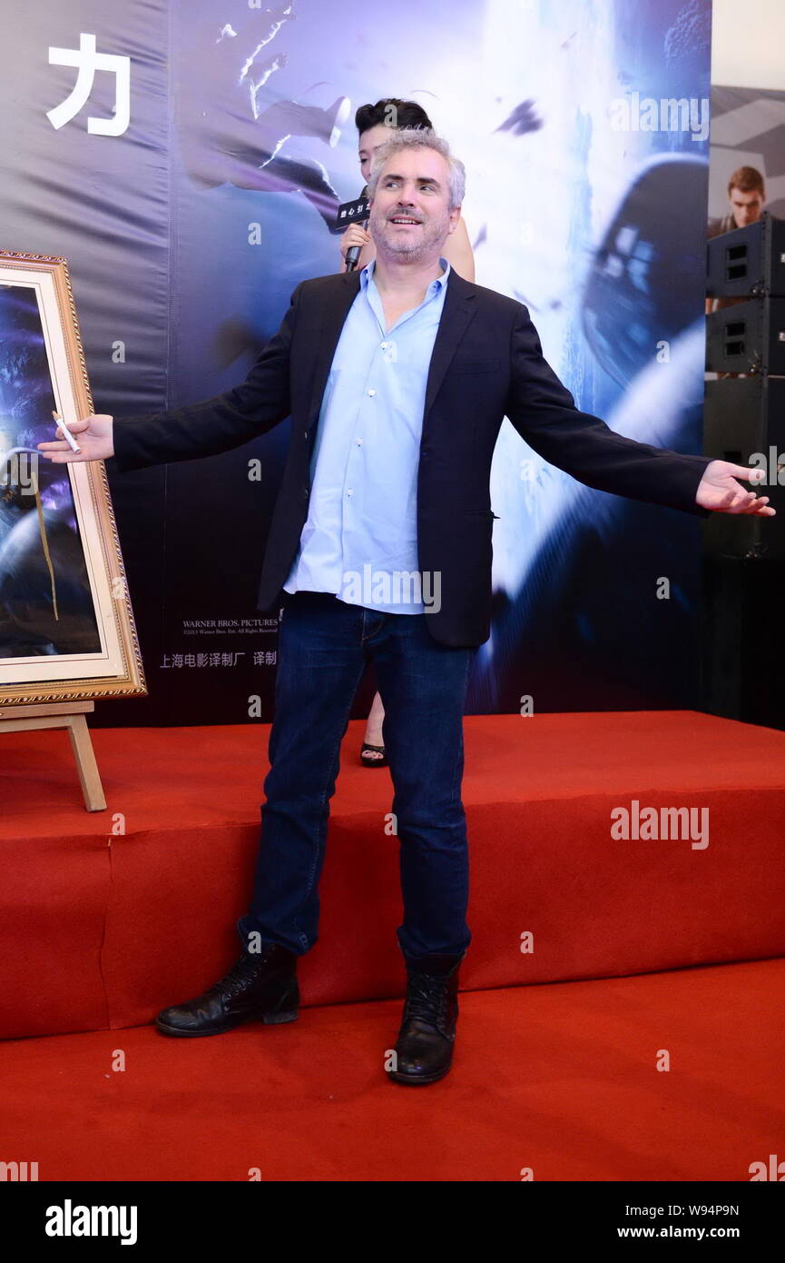 El Director De Cine Mexicano Alfonso Cuaron Posa Junto A Un Cartel De Su Nueva Pelicula Gravedad Despues Firmando En Ella Durante Una Conferencia De Prensa Para Su Prem Fotografia De Stock