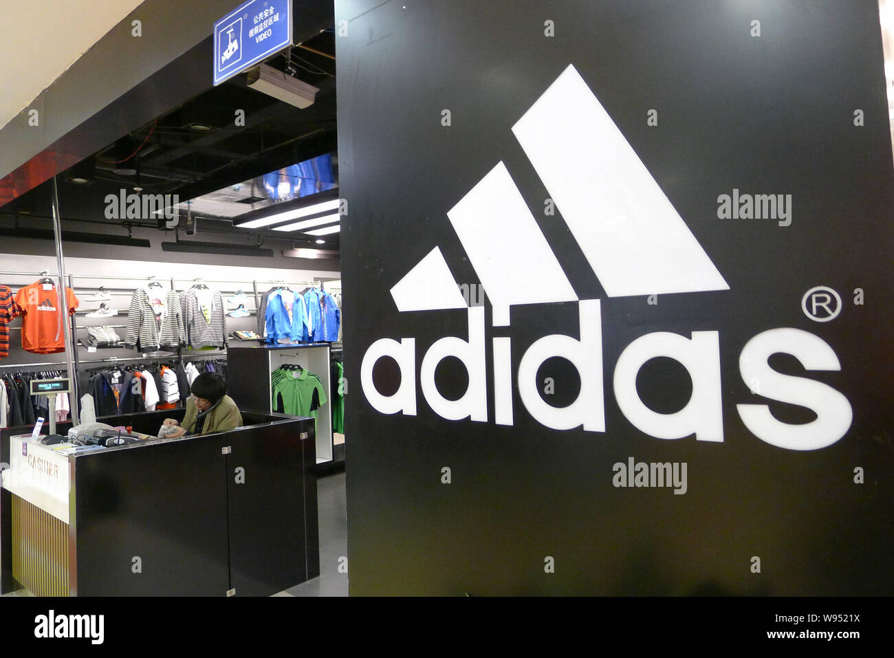 Clientes caminen en una tienda de productos deportivos de Adidas en la  ciudad de Qingdao, Provincia