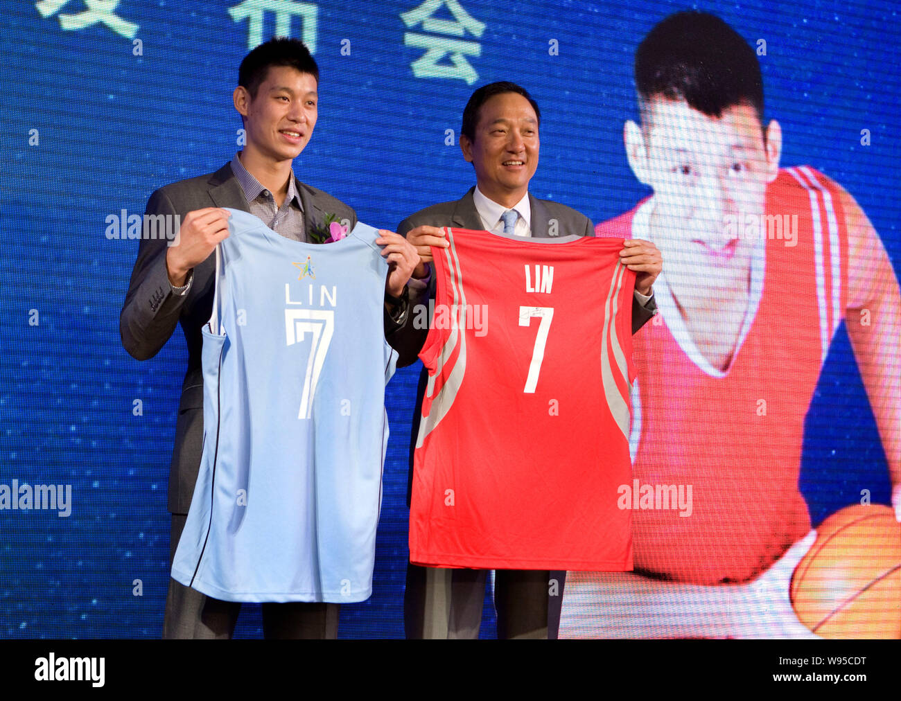La estrella de baloncesto de la NBA Jeremy Lin (L) muestra su basketball  jersey en una actividad promocional celebrada por KFC durante su Linsanity  tour en Shanghai, China, 16 Fotografía de stock -