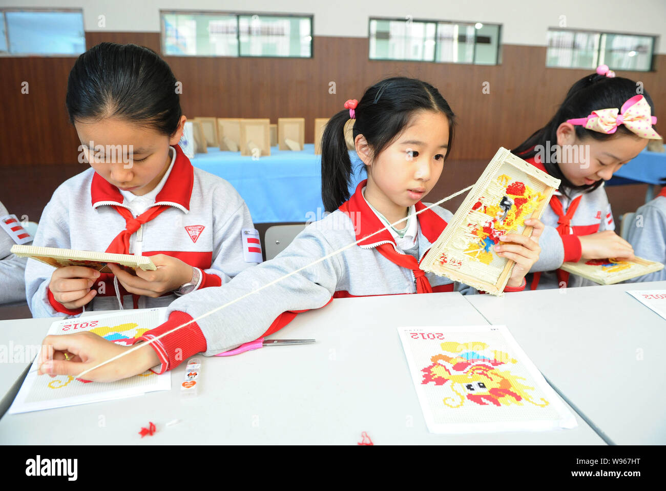 --File--las niñas hacen bordados durante una clase de artesanía en Nanyuan junior middle school en Shangai, China, 26 de abril de 2012. Mochilas escolares digital Foto de stock
