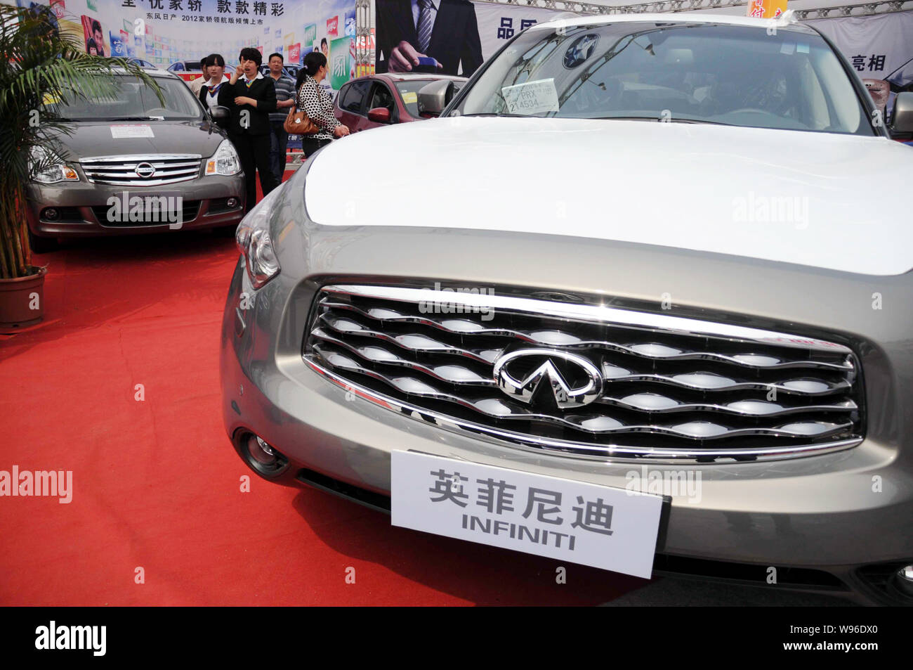 Los visitantes miran Nissan e Infiniti coches durante un auto show en Binzhou Ciudad, East chinas en la provincia de Shandong, el 22 de abril de 2012. Fabricante de automóviles de lujo Infini Foto de stock