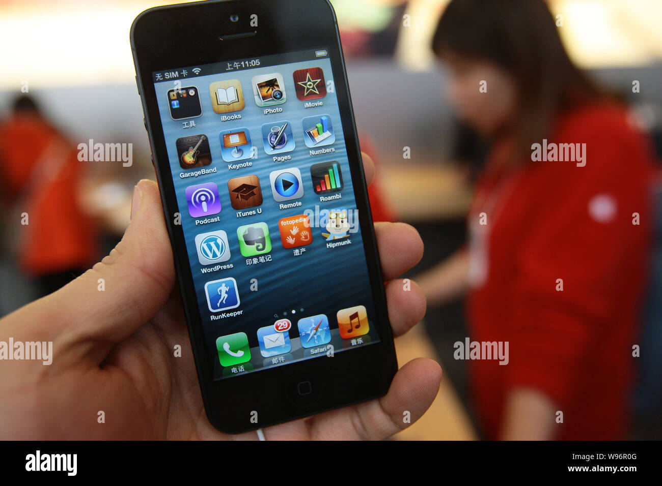 Un cliente intenta fuera un iPhone 5 smartphone en una tienda de Apple en Shangai, China, 14 de diciembre de 2012. Las ventas del iPhone 5 han comenzado en China sobre Foto de stock