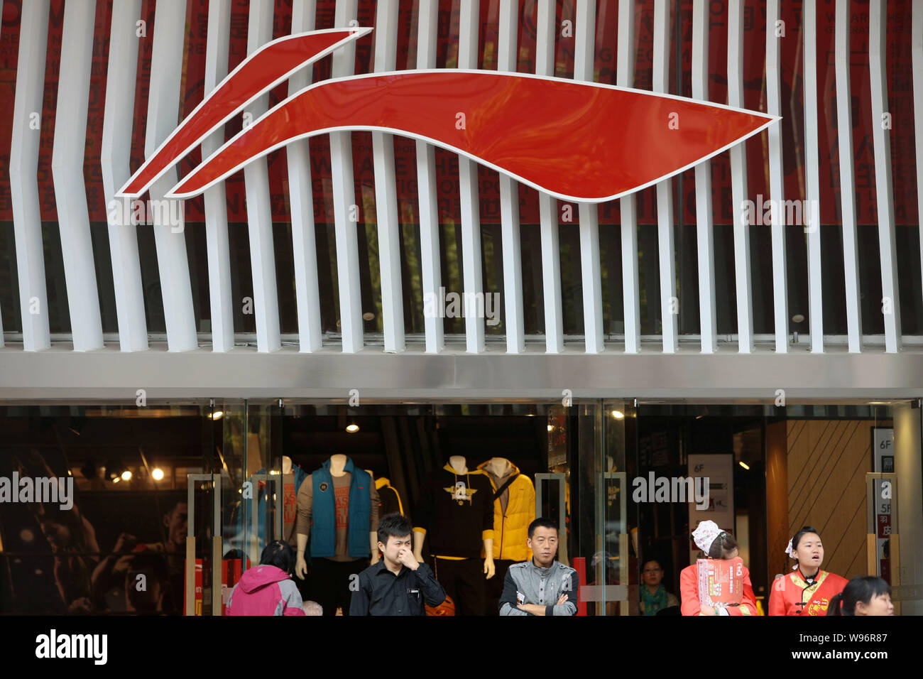 La gente se levanta fuera de una tienda de ropa deportiva Li-Ning en  Shanghai, China, 15 de noviembre de 2012. Li Ning Co., una marca china que,  una vez que aspiraba a