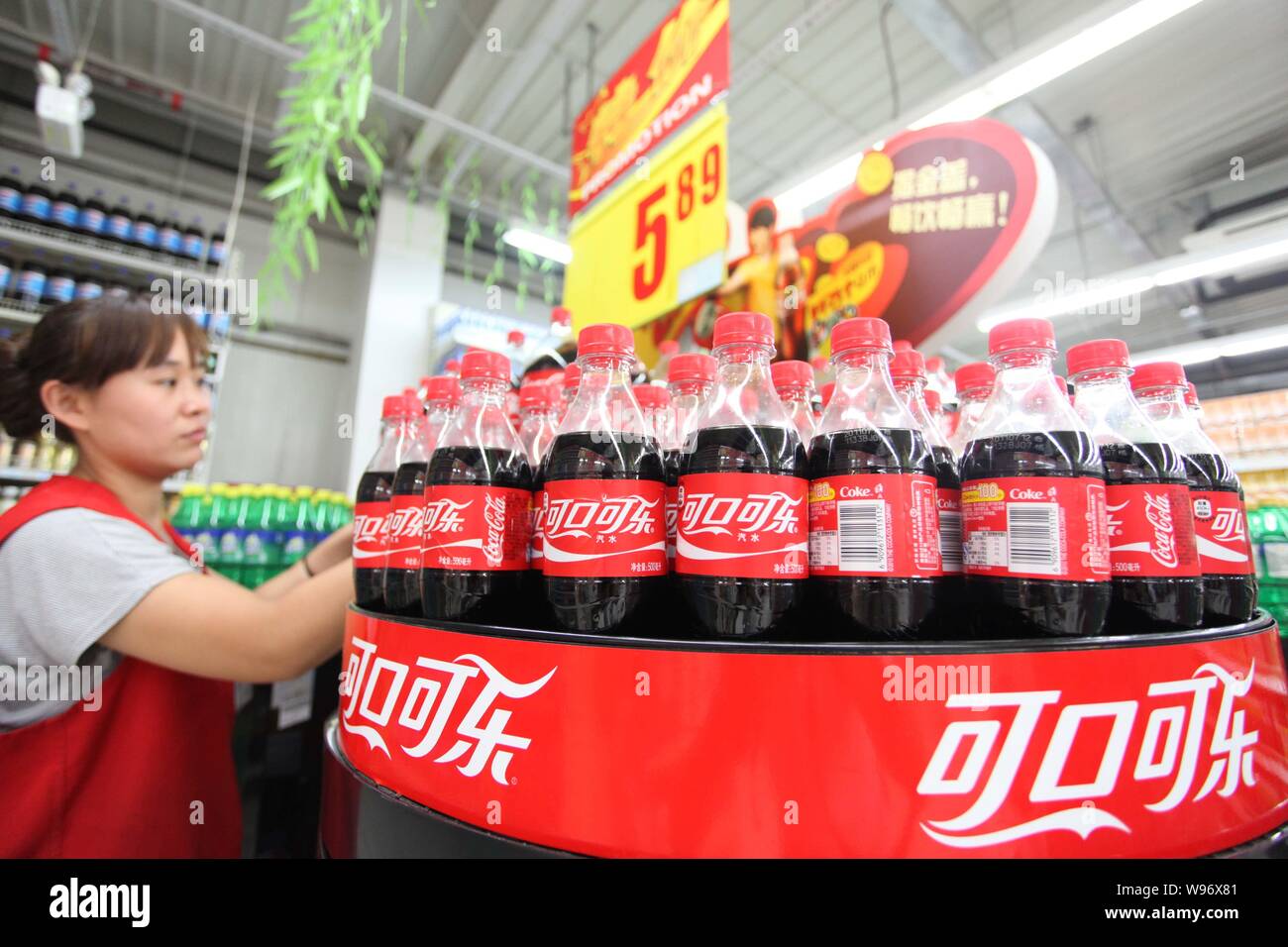 File -- Un personal chino pone botellas de Coca-Cola en la estantería de un  supermercado en Beijing, China, 26 de julio de 2011. Sólo un día después de  la exposición de la