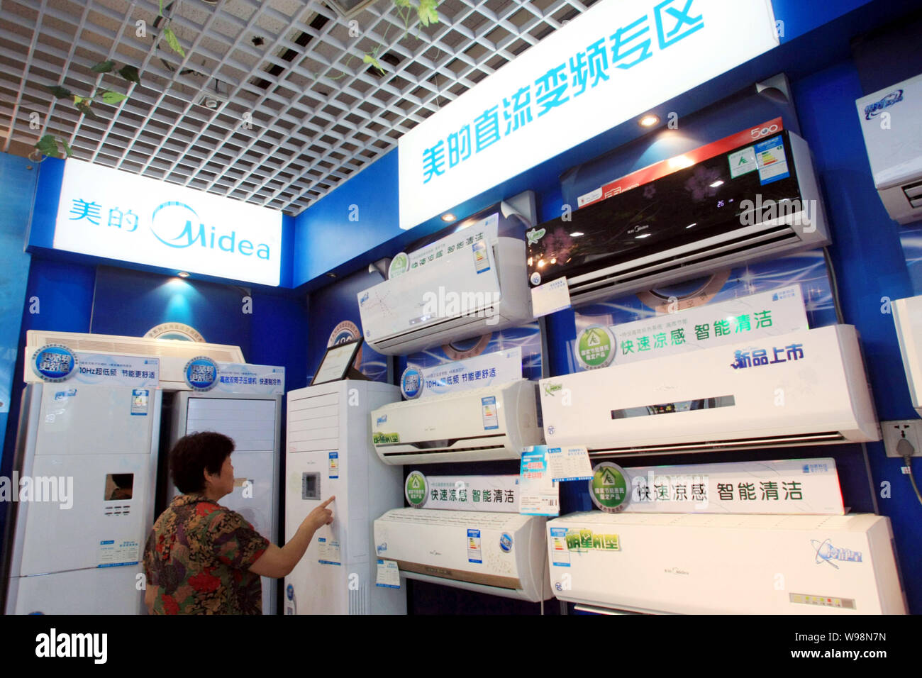 lector Jardines enjuague FILE -- Un cliente chino tiendas de aire acondicionado Midea en una tienda  de electrodomésticos en Shanghai, China, el 1 de agosto de 2011. El volumen  de ventas de aire c Fotografía