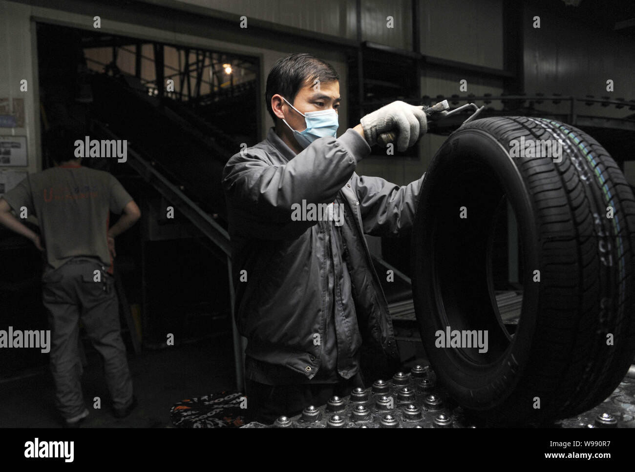 FILE--Los trabajadores chinos fabrican neumáticos en la línea de producción  en la fábrica de neumáticos Hankook en la ciudad de Jiaxing, provincia de  Zhejiang, China oriental 6 Dece Fotografía de stock -