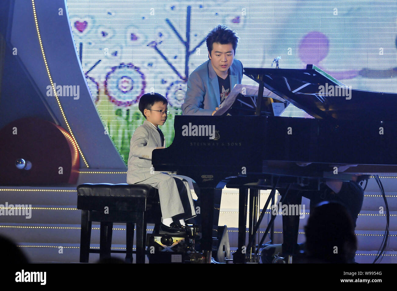 Pianista chino Lang Lang (R) es guiar a un niño a tocar el piano en una  ceremonia del 25º aniversario del Comité pro UNICEF de Hong Kong en Hong  Kong Fotografía de