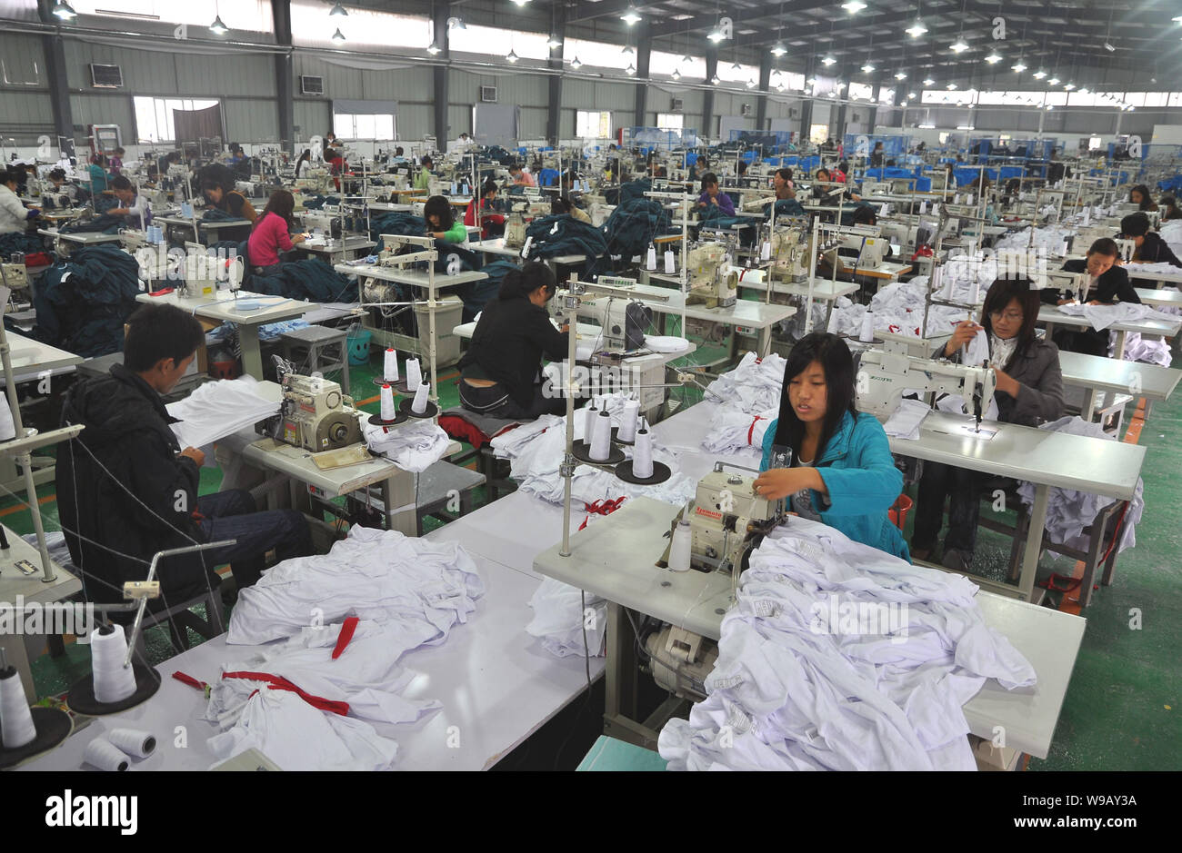 Trabajadores de fábricas chinas hacer ropa en una fábrica textil en la  ciudad de Fuyang, provincia de Anhui, China oriental, 12 de octubre de  2010. Los fabricantes de textiles chinas Fotografía de