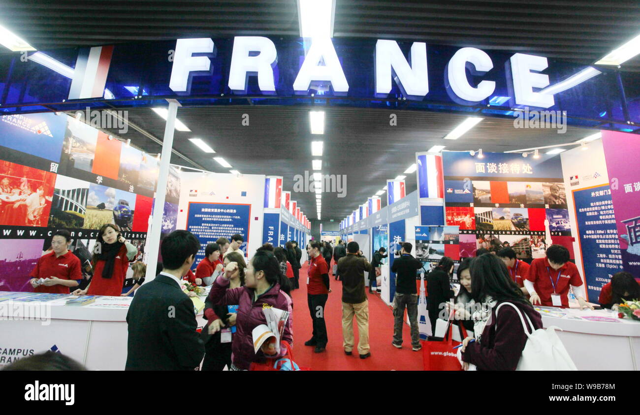 Los visitantes chinos indagar acerca de estudios en el extranjero en las cabinas de colegios o universidades francesas durante la 15ª China International Education Exhibitio Foto de stock