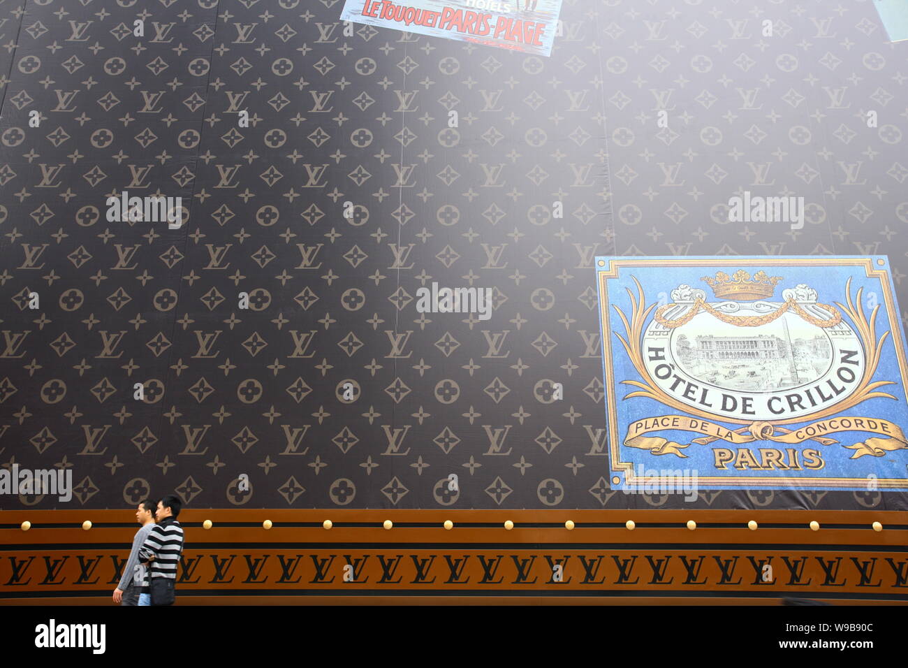 Una atractiva mujer joven llevando un Louis Vuitton (LV) Bolso camina  delante de una enorme maleta LV fuera del centro comercial Plaza 66 en  Shanghai, China, 4 de Nove Fotografía de stock - Alamy