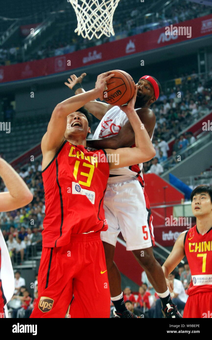 Chinas Su Wei, frontal, intenta marcar en un partido entre el baloncesto el  equipo de baloncesto nacional de China y los . Estrellas durante la  Fundación Yao C Fotografía de stock -