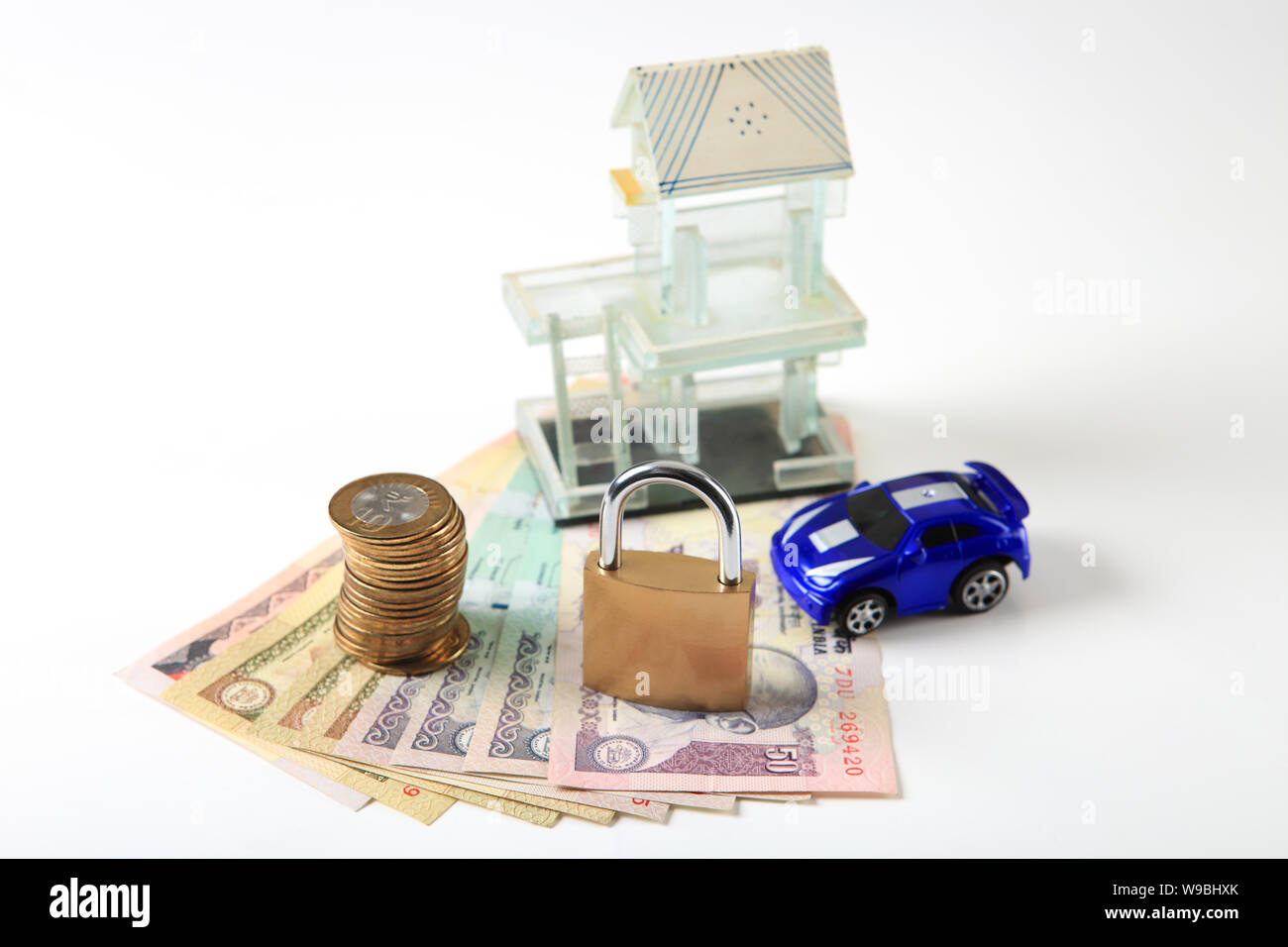 Candado en el dinero con modelo de casa y coche de juguete Fotografía de  stock - Alamy