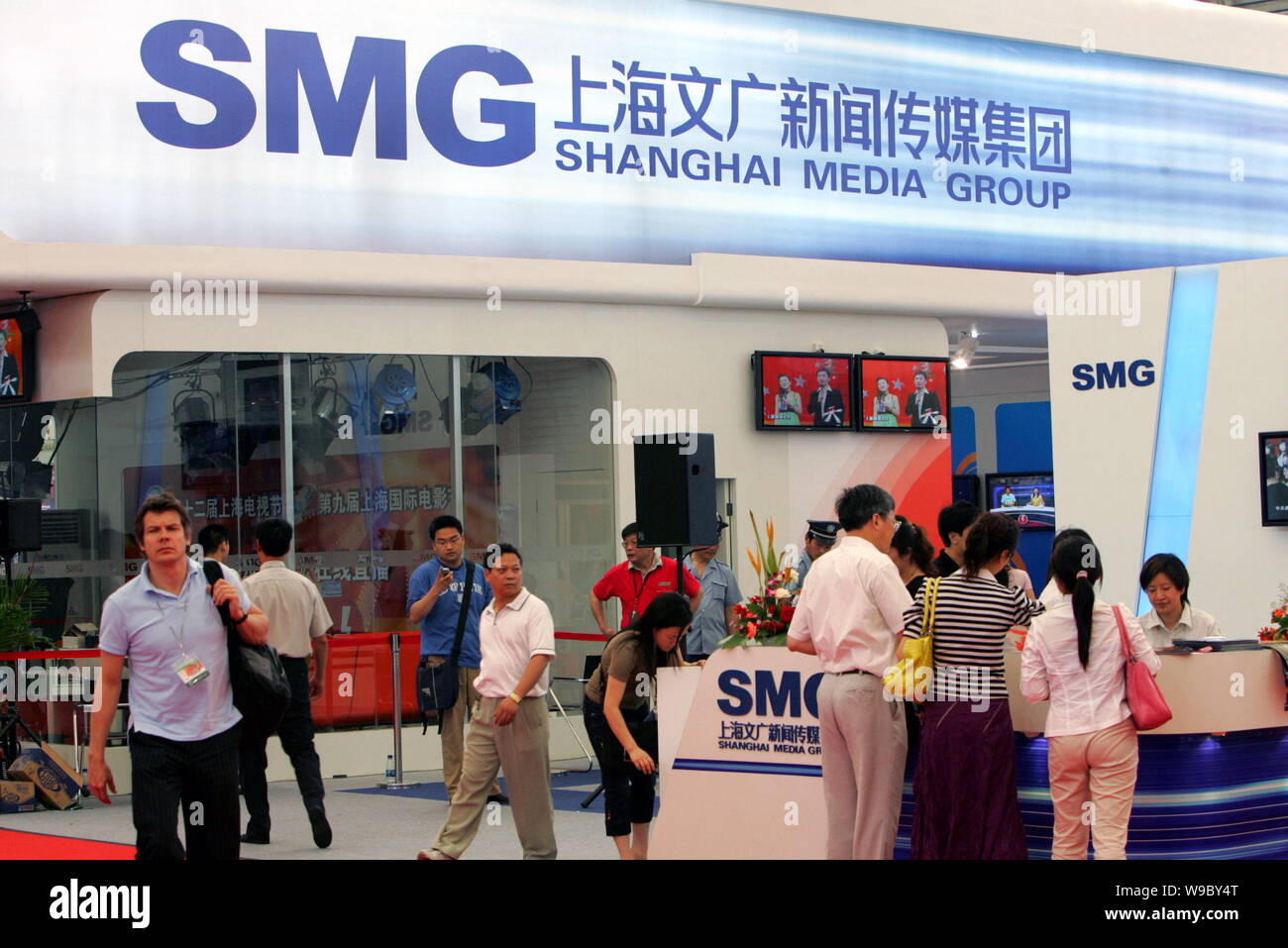 --FILE-- Los visitantes son vistos en el stand de Shanghai Media Group (SMG) durante una exposición en Shanghai, China, 19 de junio de 2006. Shanghai Media Group ( Foto de stock
