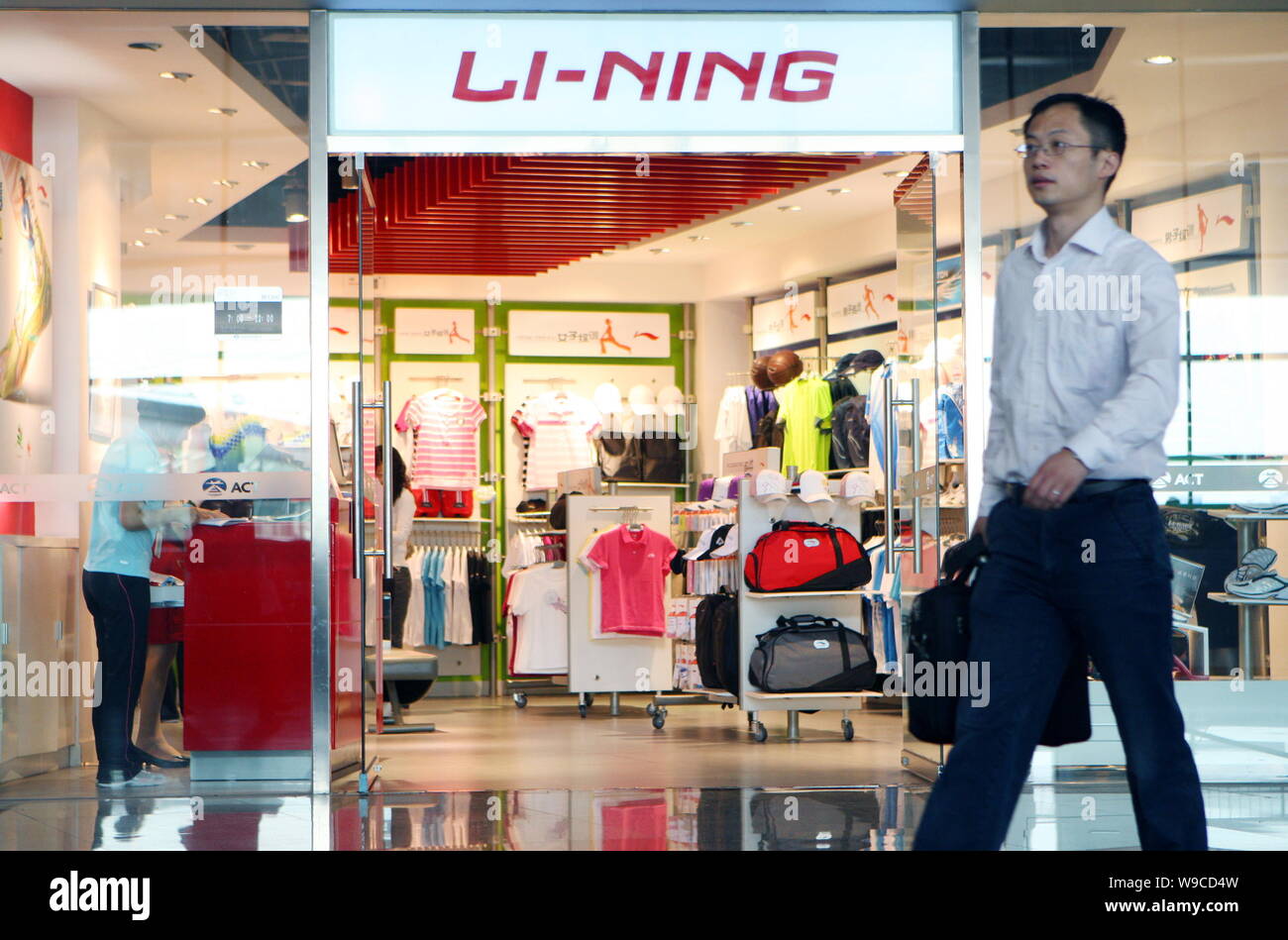 FILE -- un hombre camina chino ha pasado de una tienda de ropa deportiva  Li-Ning en Beijing, China, 30 de abril de 2009. Marca deportiva china  Li-Ning empresa planea abrir Fotografía de
