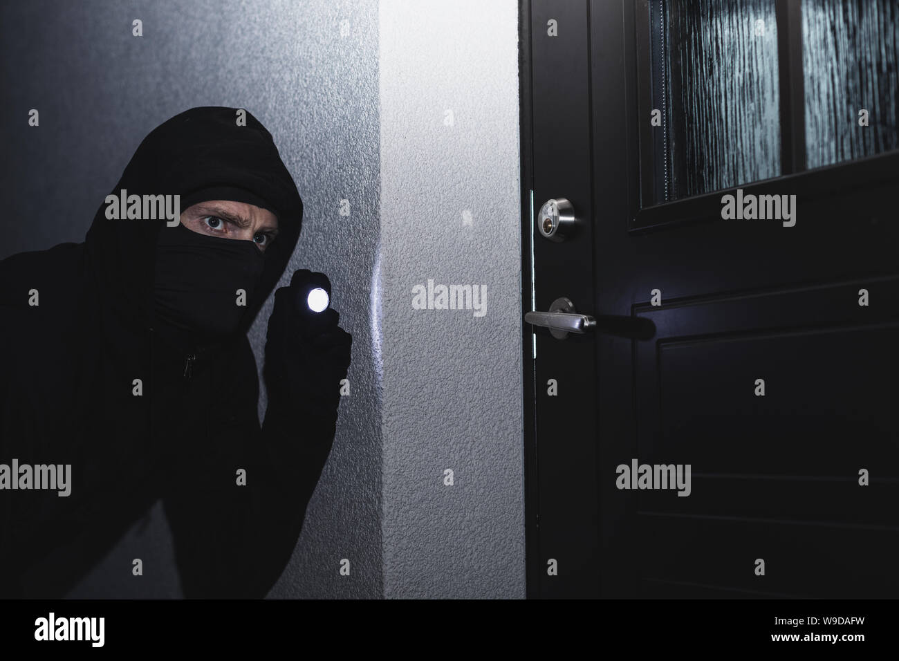 Ladrón en máscara dispuesta a romper en la casa durante la noche Foto de stock