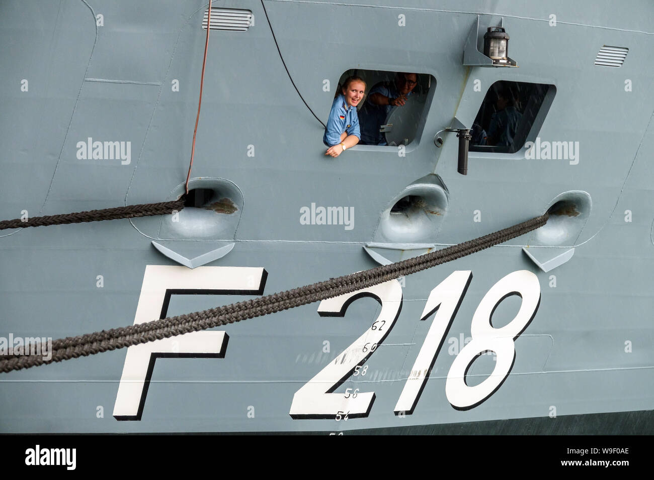 Una mujer miembro de la tripulación en una ventana en la popa de un barco, mujeres del ejército alemán fragata alemana Mecklenburg-Vorpommern en Rostock Alemania marina Foto de stock