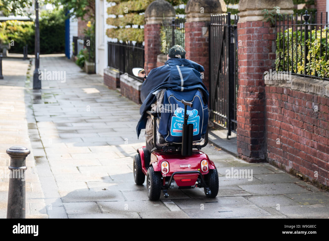 Un Anciano Montando Un Scooter De Movilidad En Una Acera O Vereda