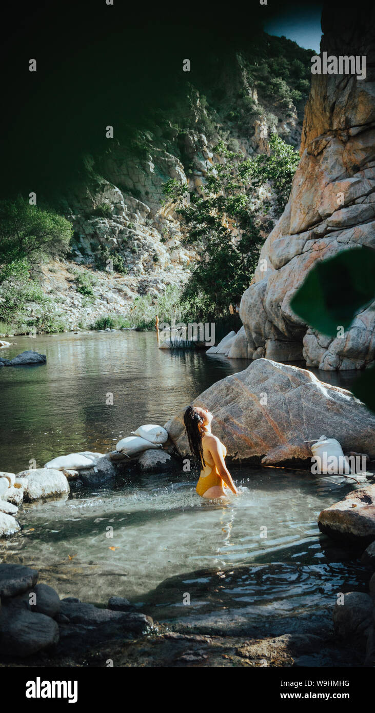 Modelo femenino chapoteando en el agua pelo en deep creek hot springs en California, Estados Unidos. Foto de stock