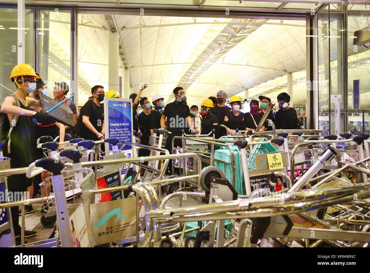 Hong Kong. 13 Aug, 2019. Los disturbios estallan en el Aeropuerto Internacional de Hong Kong, cuando la policía intentan rescatar a dos hombres chinos que son sospechosos de ser agentes encubiertos de la China continental y, por tanto, retenidos por los manifestantes en el interior del aeropuerto. Los enfrentamientos estallan a media noche, spray de pimienta se usa y unos pocos manifestantes son arrestados. Crédito: Gonzales Foto/Alamy Live News Foto de stock