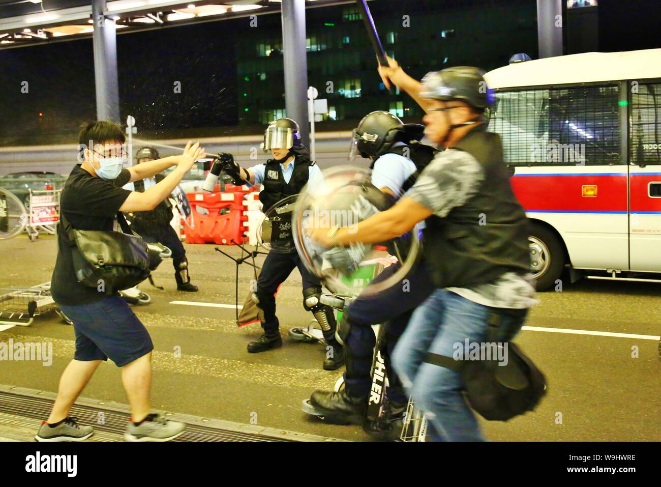 Hong Kong. 13 Aug, 2019. Los disturbios estallan en el Aeropuerto Internacional de Hong Kong, cuando la policía intentan rescatar a dos hombres chinos que son sospechosos de ser agentes encubiertos de la China continental y, por tanto, retenidos por los manifestantes en el interior del aeropuerto. Los enfrentamientos estallan a media noche, spray de pimienta se usa y unos pocos manifestantes son arrestados. Crédito: Gonzales Foto/Alamy Live News Foto de stock