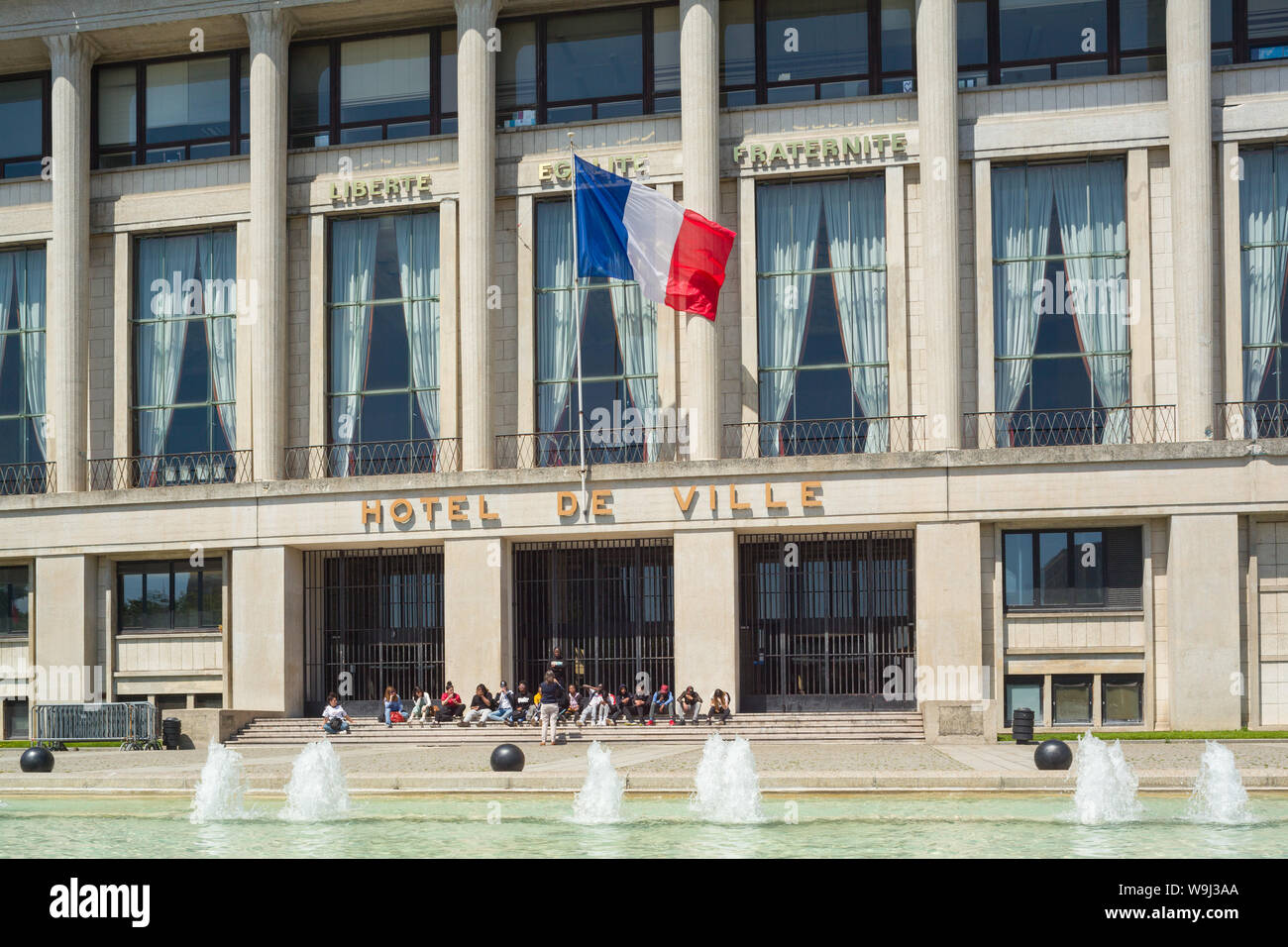 La Bandera Nacional de Francia o el Tricolore vuela sobre el frente del Hotel de Ville o Ayuntamiento en Le Havre Foto de stock
