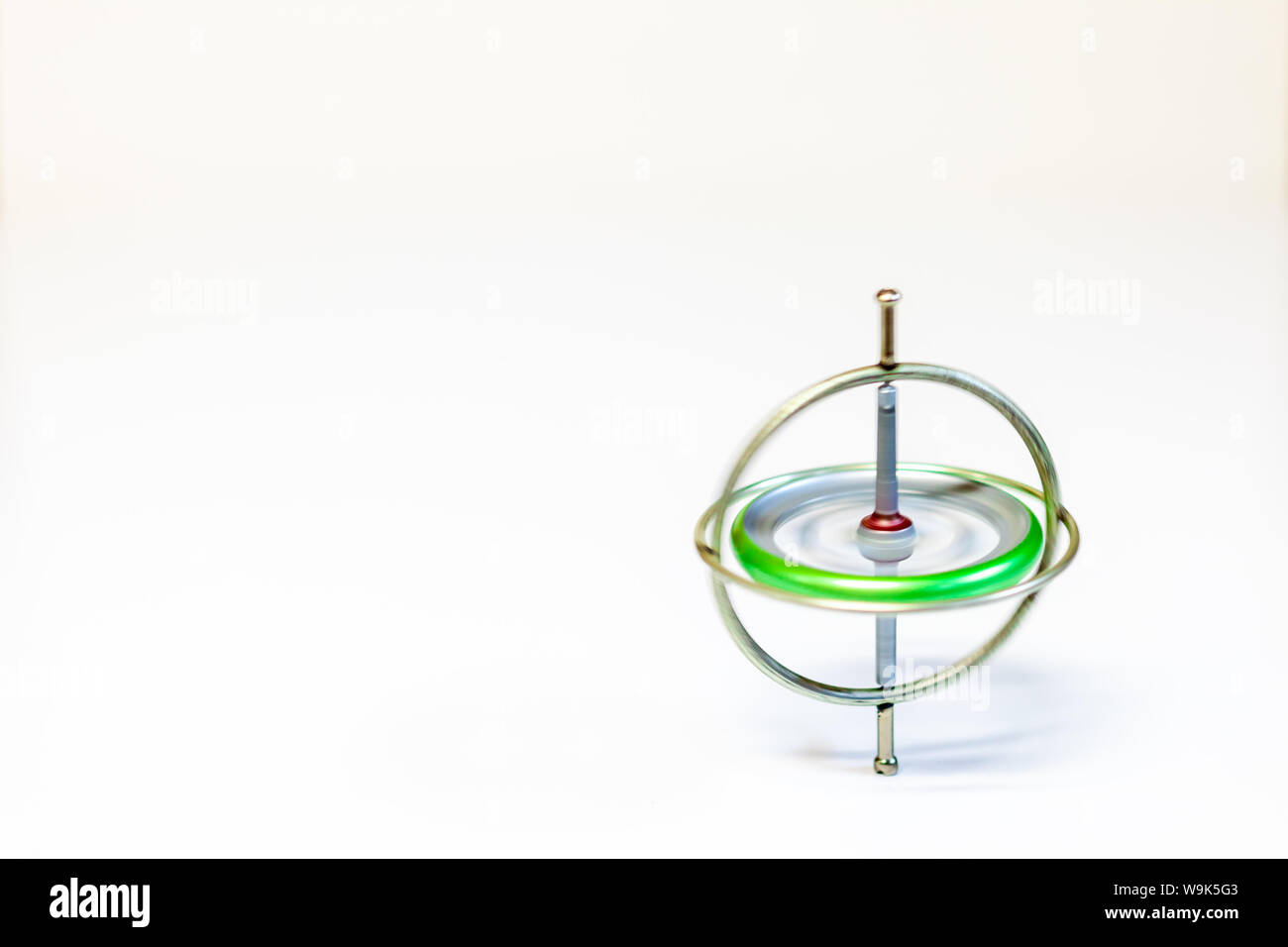 Un juguete de metal hilado giroscopio aislado sobre un fondo blanco. Foto de stock