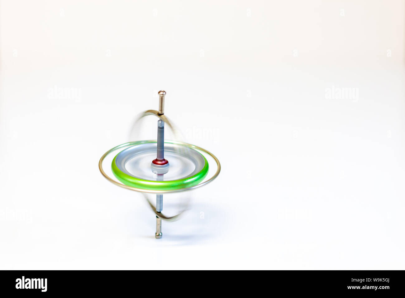 Un juguete de metal hilado giroscopio aislado sobre un fondo blanco. Foto de stock