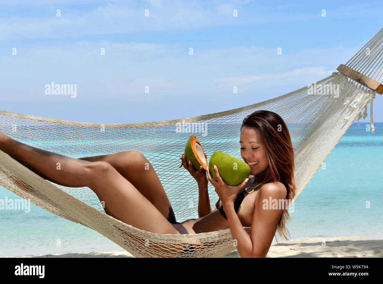 Chica en una hamaca con dulce de coco, Playa de Bohol, Filipinas, el sudeste de Asia, Asia Foto de stock