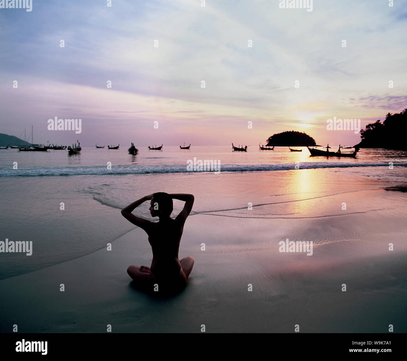 Chica haciendo yoga en la playa de Kata, Puket, Tailandia, el sudeste de Asia, Asia Foto de stock