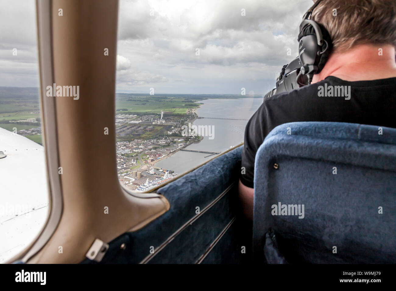 Fotógrafo aéreo en el trabajo sobre el puerto de Invergordon, Highland, Escocia Foto de stock