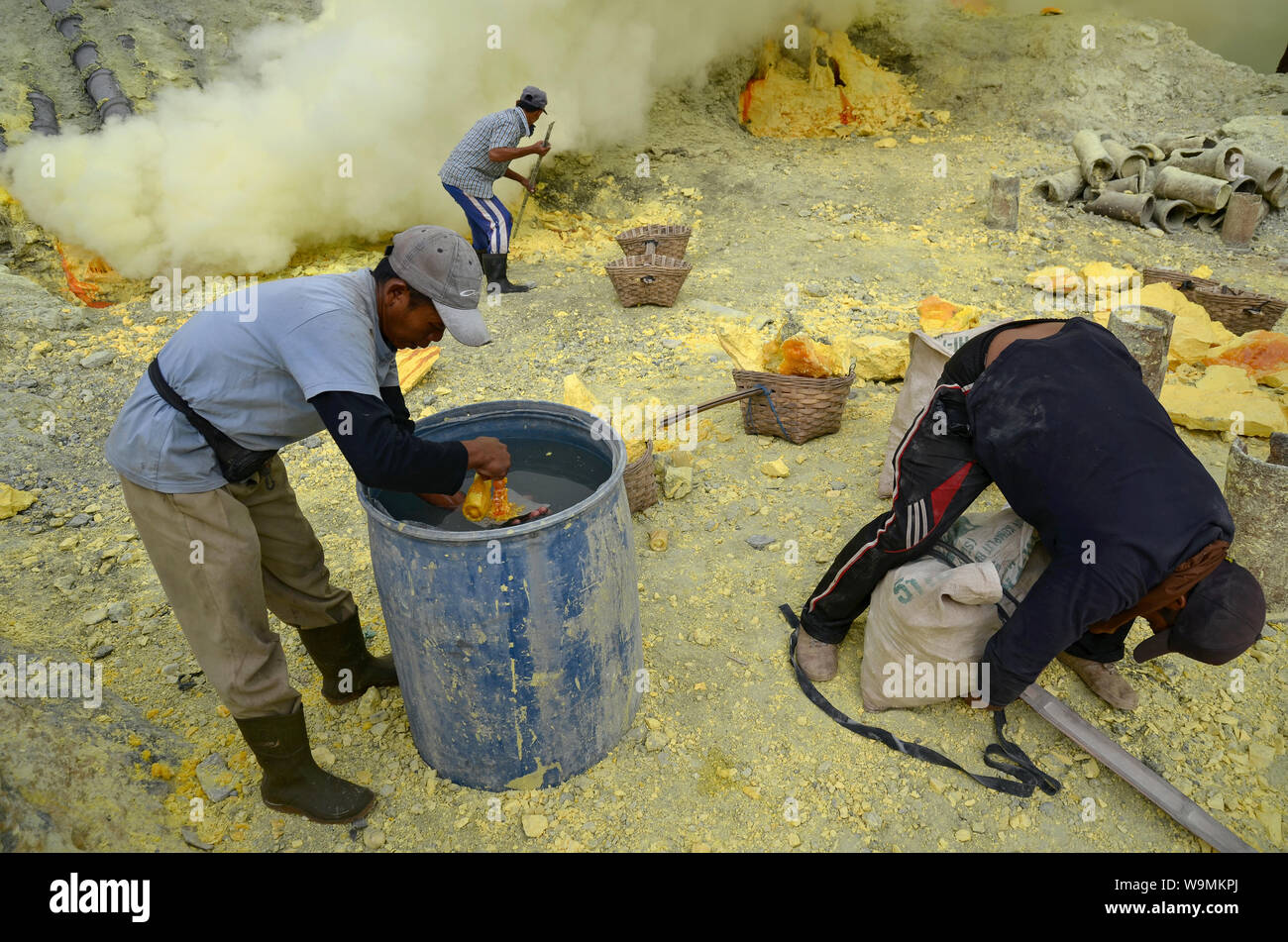 JAVA ORIENTAL, INDONESIA - Mayo 18, 2014: los mineros que extraen el azufre en el interior del cráter del volcán Kawah Ijen. Foto de stock