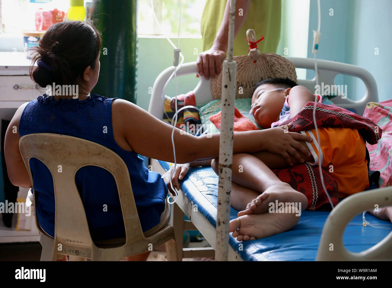 Laguna, Filipinas. 15 Aug, 2019. Una madre atiende a su hijo asolado por dengue de dormir dentro de un dengue ward del Dr. José P. Rizal Memorial Hospital de Distrito de la provincia en la provincia de Laguna, Filipinas, el 15 de agosto, 2019. El Departamento de Salud (DOH) de Filipinas, dijo el martes que los casos de dengue en el país han llegado a 167,607 con 720 muertes desde enero de este año. Crédito: Rouelle Umali/Xinhua/Alamy Live News Foto de stock