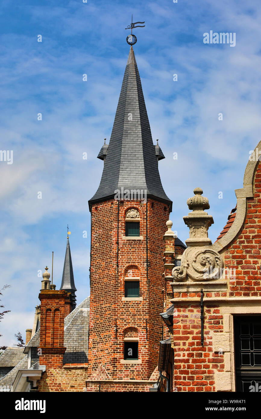 Torre medieval y decoraciones sobre el techo tradicional Huidevettershuis, Brujas, Bélgica Foto de stock
