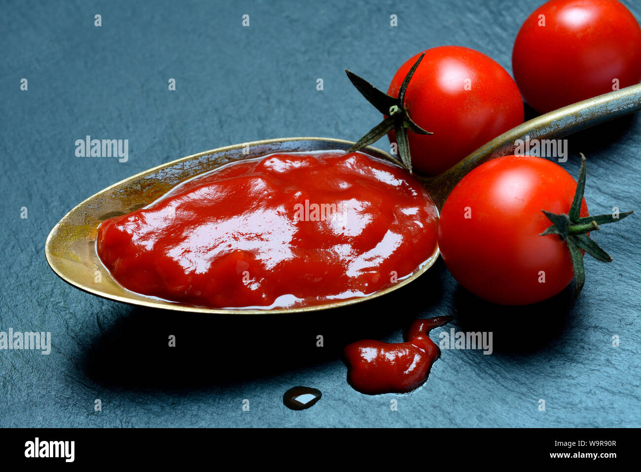 La salsa de tomate ketchup en cuchara, tomates Foto de stock